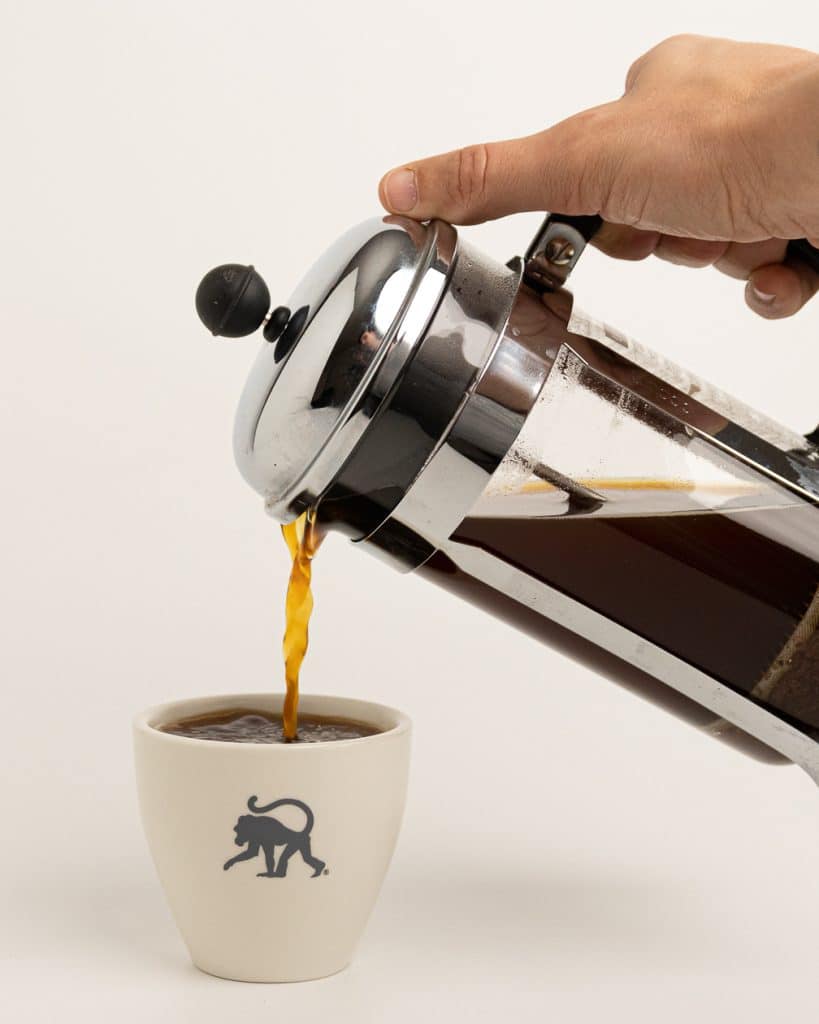 coffee being poured out of French press brewer