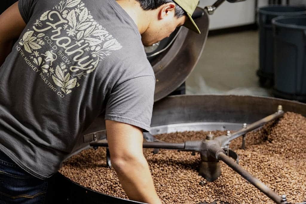 Frothy Monkey employee roasting coffee beans.